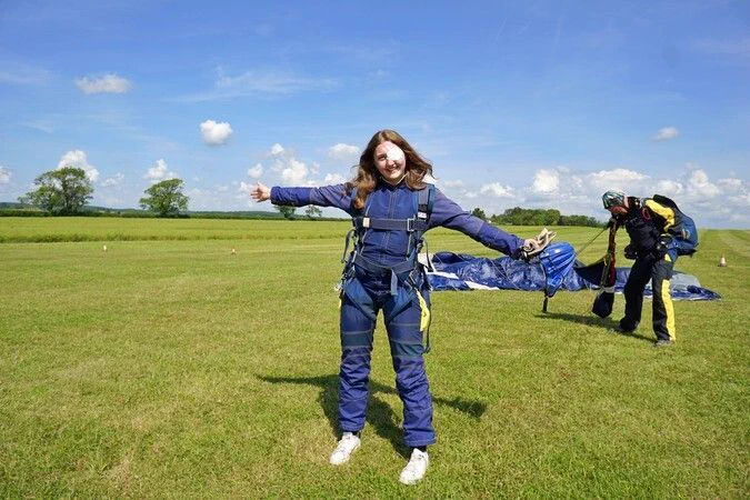 An Rb teen member posing and smiling after completing her sky dive. 