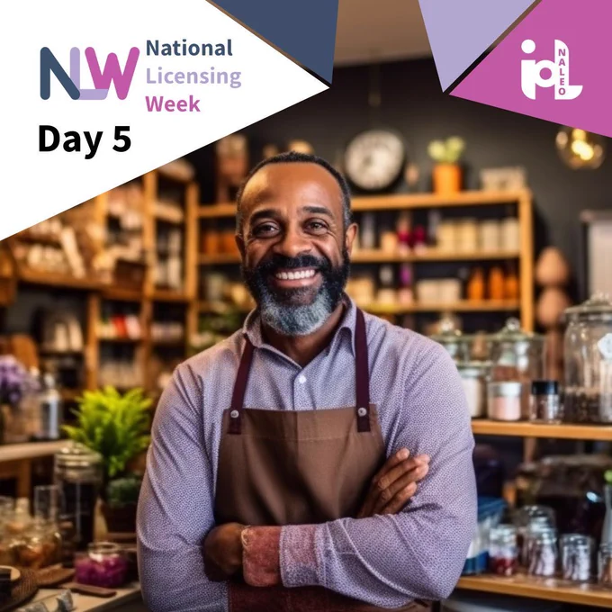 Day 5 of National Licensing Week 2026. A smiling business owner stands confidently in their premises wearing an apron, shelving and products visible in the background. NLW 2026 branding top left.