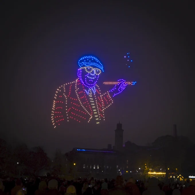 Photograph of lights on a dark sky in the outline of David Hockney.