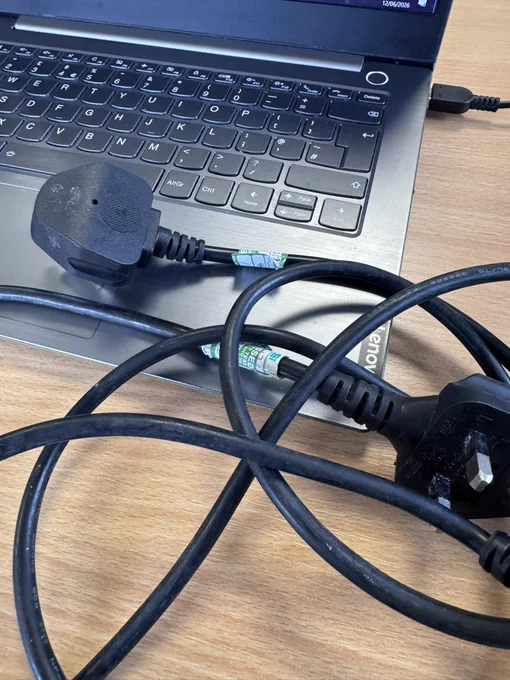 Corner of laptop and power leads.