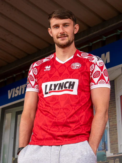 Josh Steele wearing a red shirt with white rose patterns and 'Lynch' sponsor logo standing outdoors.