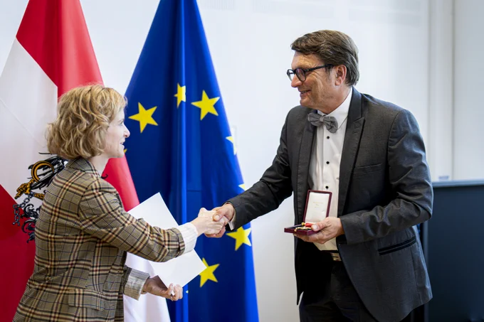 Clemens Ruthner accepting the Honorary Cross for Science and the Arts from the hands of Austrian Minister of Science and Research, Eva-Maria Holzleitner.