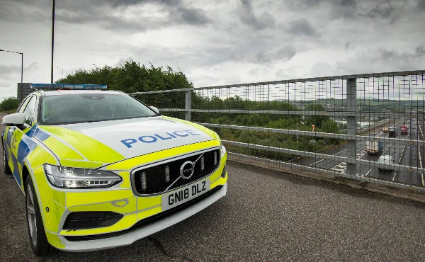 Photo of a police car parked on a motorway bridge.