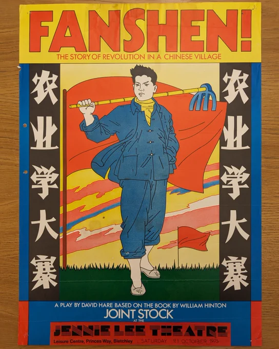 A colourful poster for ‘Fanshen!’ on a tabletop. The main image is of a Chinese farmer carrying a hoe, posing in front of a red flag. The background shows a bright, colourful sky. The text on the images reads ‘FANSHEN! / THE STORY OF REVOLUTION IN A CHINESE VILLAGE / a play by David Hare based on the book by William Hinton / Joint Stock at the Jennie Lee Theatre, Leisure Centre, Princes way, Bletchley, Saturday 18 October, 1975