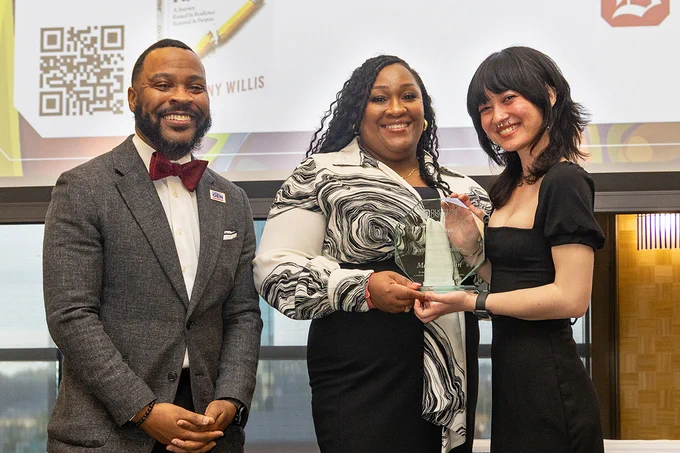 Malka, right, holds her Spirit of Community Building Award next to Amber Satterwhite, center, and Dr. Quincy Stevenson, left.