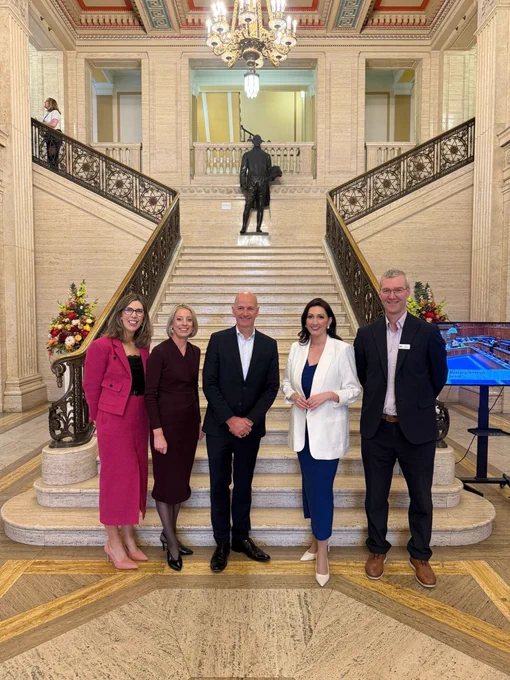 Image of five people - including deputy First Minister Emma Little-Pengelly - standing in front of steps in Great Hall at Parliament Buildings