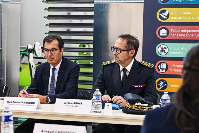 Le ministre et le préfet sont assis à table, ils écoutent les interlocuteurs d’une réunion.