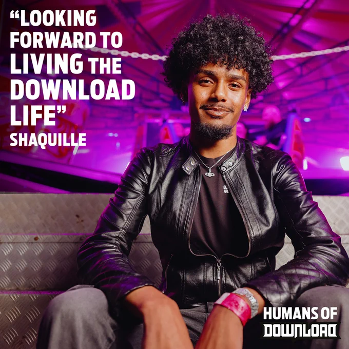 Person with curly hair wearing a black leather jacket sitting on a metal bench under purple lighting, with a quote about living the Download life.