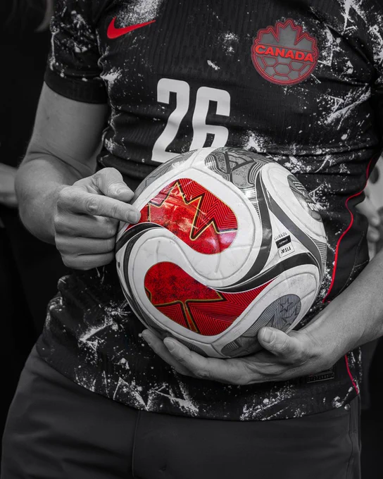 Canadian Prime Minister Mark Carney points to a red maple leaf on the FIFA World Cup soccer ball during a FIFA World Cup 26™ event in Ottawa.