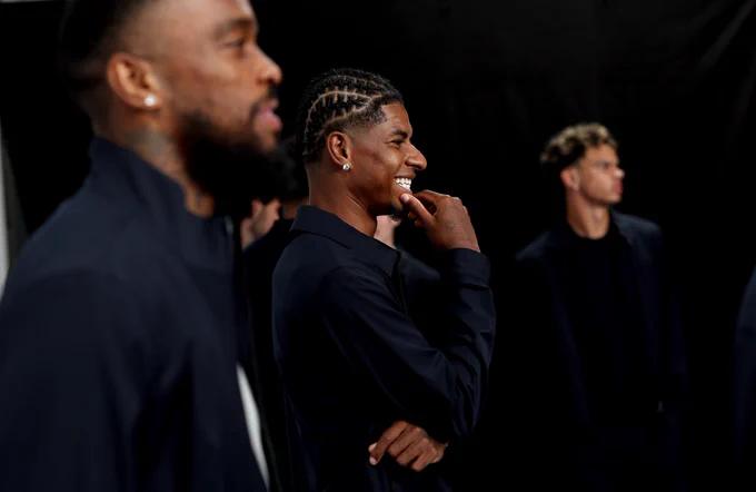 Marcus Rashford smiles as he watches on during the photoshoot