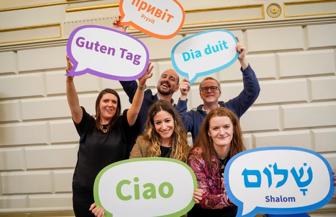 Attendees at the Languages Alumni Summer Social holding greeting signs in some of the languages taught in the School.