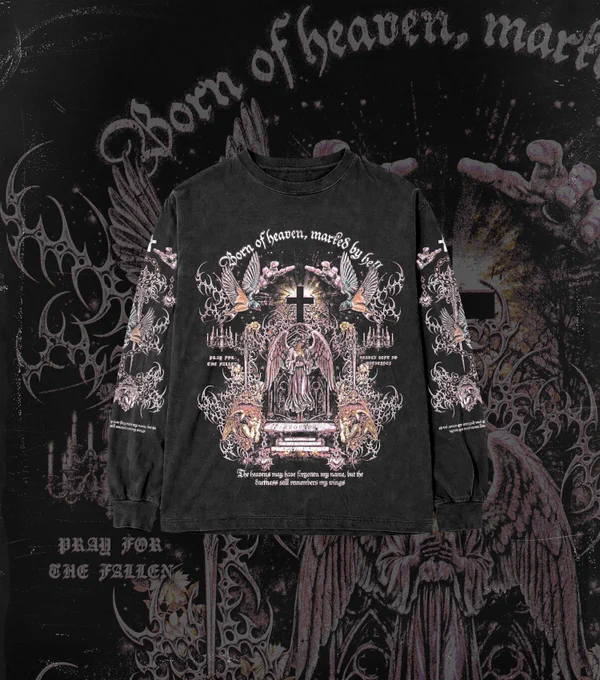 Dark fashion aesthetic: A black long-sleeve tee with an elaborate Y2K gothic grunge graphic print on the front and sleeves. The design includes angels, a central cross, and heavy metal-style typography, set against a dark, dramatic backdrop