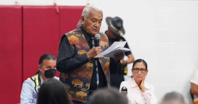 Indian Boarding School survivor Ray Doyah reads poetry as Secretary Deb Haaland and Assistant Secretary Bryan Newland sit in the background, on Saturday, July 9, 2022, in Anadarko, Okla.