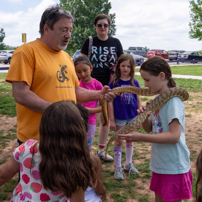 Raging Reptiles hosts a program with a snake wrapped around a girl's neck.
