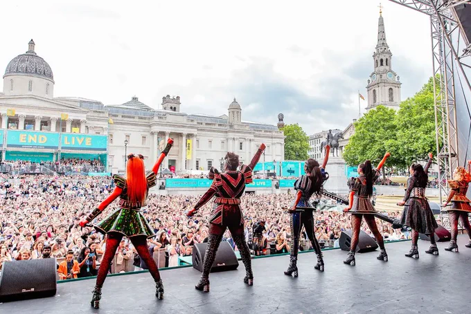 A photo showing a cast of performers standing on. a stage 