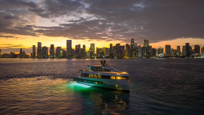 Sunset view of a Wally motor yacht illuminated in front of the Miami bay