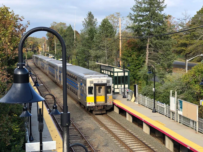 An overhead shot of an LIRR train departing from Stony Brook station on a cloudy day.