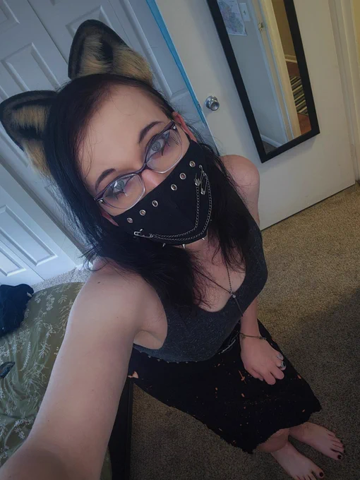 a picture of me bending down in my bedroom, I'm wearing raccoon ears, a face mask, a tank top, and a skirt. I have bare feet