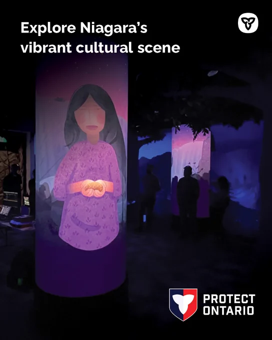 Indoor cultural exhibit featuring tall cylindrical displays illuminated with vibrant purple and pink artwork. Text: Explore Niagara’s vibrant cultural scene.