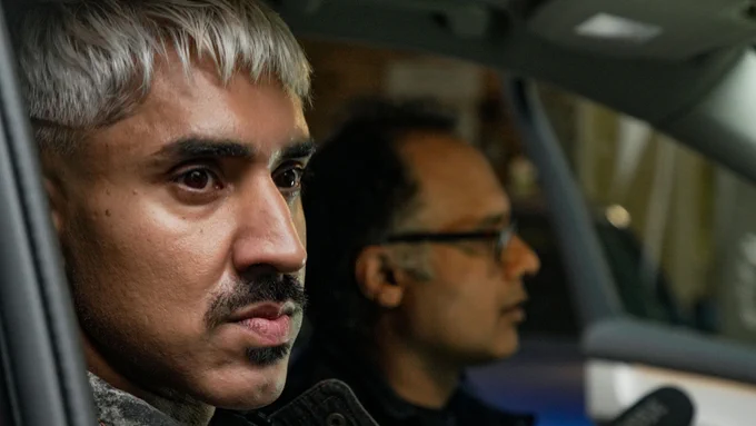 Mobeen Azhar and Masood Khan looking out from a car