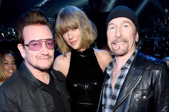 Bono and Edge standing on either side of Taylor Swift.