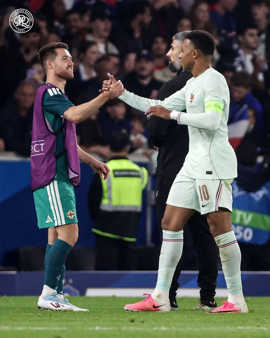 Paul Smyth (left) shaking hands with Kylian Mbappe (right).