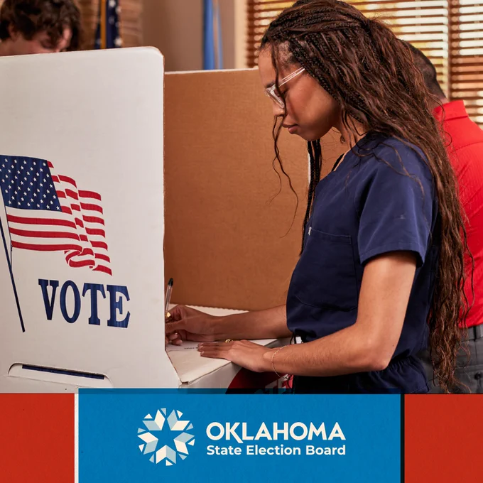Photograph of people voting in their voting booths with the text "Vote" across the right-hand corner of the photograph
