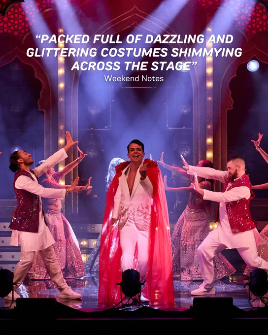 Performers in bright, shimmering costumes are energetically dancing on stage. The background features ornate arches, and a glowing review quote from Weekend Notes stating that the production is "packed full of dazzling and glittering costumes shimmying across the stage" is displayed above them.
