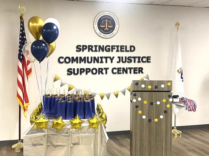 Decorations, gift bags, balloons, and a podium are arranged for a ceremony at the Springfield Community Justice Support Center.