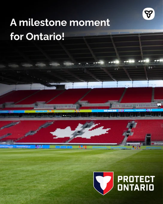 Wide view of a soccer stadium with red seats forming a maple leaf design on the stands.