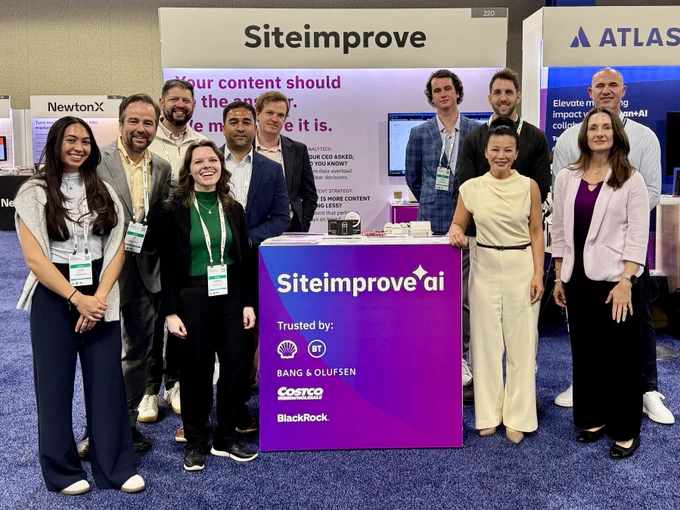 The Siteimprove team — ten people smiling together in front of a branded booth backdrop — at Gartner Marketing Symposium. The backdrop reads "Your content should be the answer. We make sure it is." with the Siteimprove AI logo and enterprise customer logos including Shell, BT, Costco, and BlackRock.