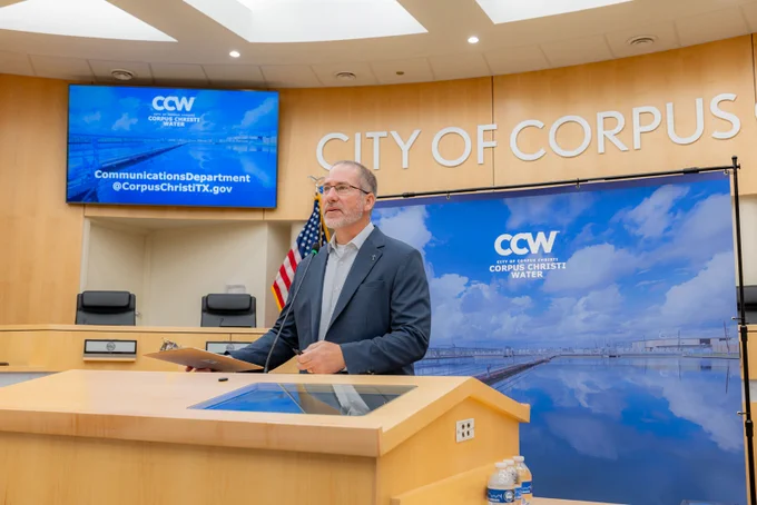 Nick Winkelmann, Chief Operating Officer of Corpus Christi Water, speaks at a podium inside the City Council Chambers at Corpus Christi City Hall.
