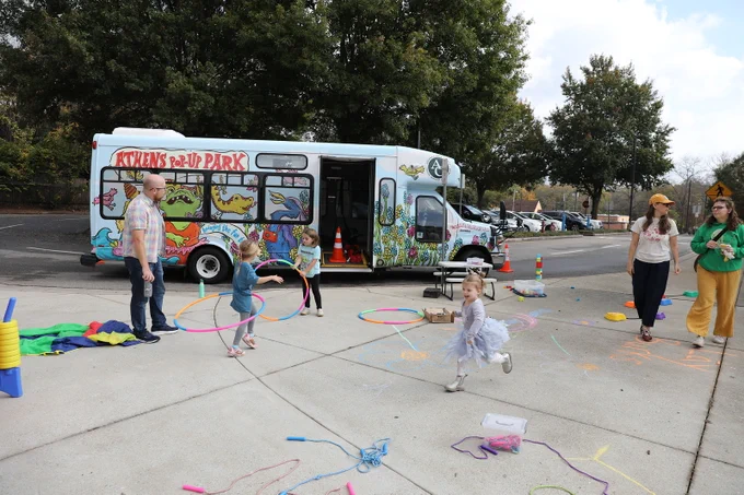 The Athens Pop-up Park set up at a school event, with children hula hooping in front of it.