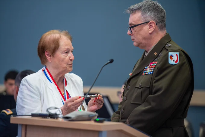 Jocelyne Papelard-Brescia, director of U.S. Memory Grand Est France in Epinal, France, presents Maj. Gen. Thomas H. Mancino, adjutant general for Oklahoma, with soil taken from a foxhole where two members of the 45th Infantry Division were killed in World War II during a ribbon cutting ceremony for the Oklahoma National Guard Museum in Oklahoma City, June 11, 2026. Papelard-Brescia shared with Mancino and those in attendance how the people of France adopted the graves of the unknown Soldiers and cared for them and how the Soldiers were recently identified and are now honored by name, Staff Sgt. John A. Rowlen and Pvt. Edward Kaszuba, both members of the 179th Infantry Regiment, 45th Infantry Division. (Oklahoma National Guard photo by Anthony Jones)\n