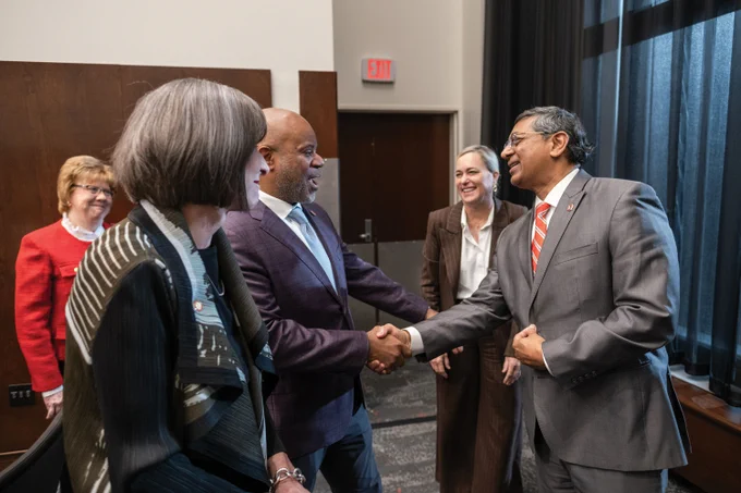 Ravi Bellamkonda shaking hands with members of the Board of Trustees after being named president