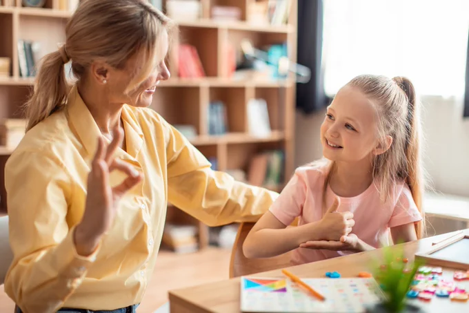 An adult and child sitting together during a speech pathology appointment. 