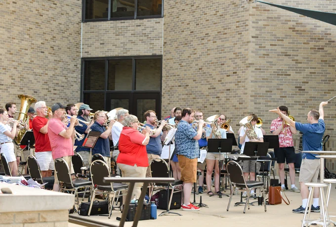 Capital City Brass Band musicians stand to perform the National Anthem. 