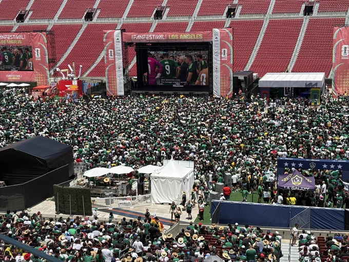The photo shows the main stage of the FIFA Fan Festival at Expo Park in Los Angeles. The photo shows soccer fans gathering in front of the stage to watch a live performance.