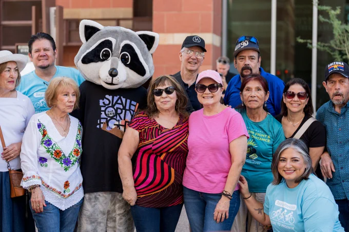 Supporters pose for a photo with Parky, the WPC racoon mascot