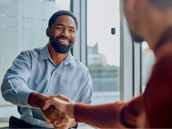 Two businessmen shaking hands. One is smiling