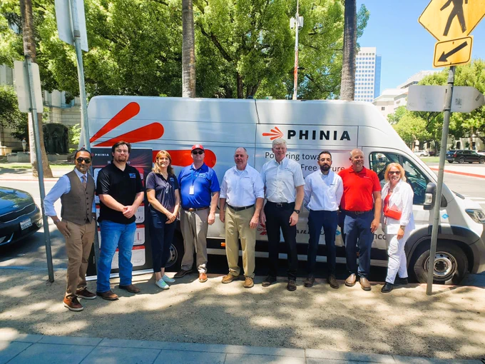 A group standing in front of the demonstration vehicle