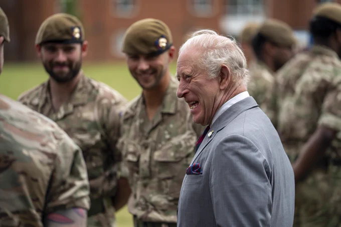 The King shares a humorous moment, laughing with the Grenadier Guards outside in their barracks in Aldershot