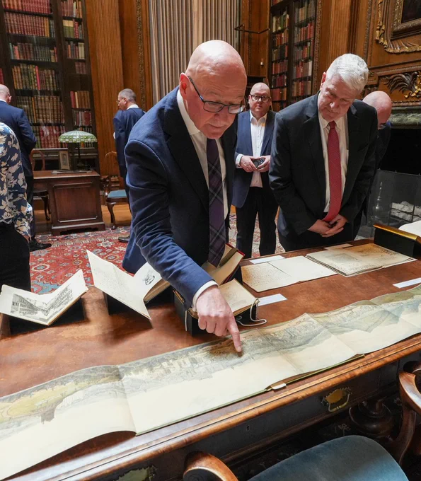 First Minister John Swinney viewing a historic illustration of Boston at Harvard University. 