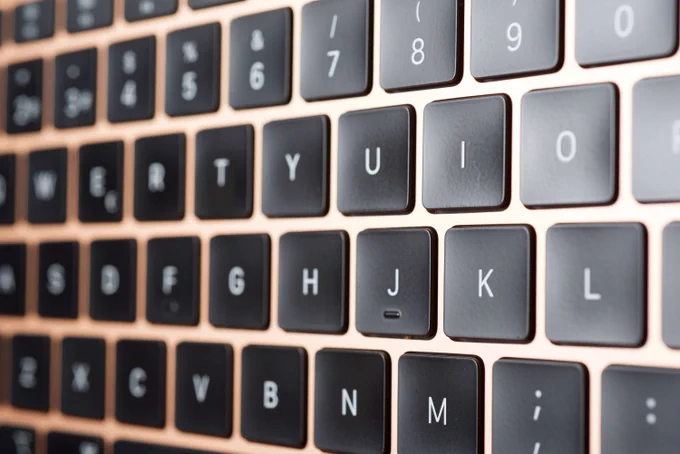 Close‑up of MacBook butterfly keyboard keys, highlighting low‑profile design prone to dust interference, key failure, and typing inconsistencies.