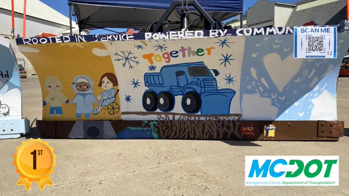 Colorful mural on a concrete barrier featuring diverse children, a blue truck, and the word 'together' with snowflakes and hearts.