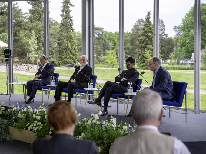 Senior Advisor to the Cabinet of Japan Takeo Akiba, Former Prime Minister of Australia Kevin Rudd, and President of Observer Research Foundation Samir Saran sitting on stage in a discussion moderated by journalist Gideon Rachman.
