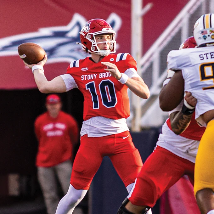 A Stony Brook football player prepares to throw a pass during a game.