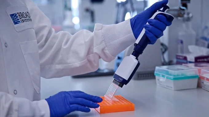 Scientist using a pipette to transfer samples into a lab tray