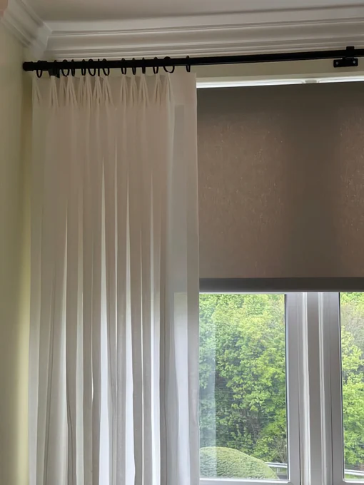 Clean lines. Controlled softness. Seamless execution.

These top-tacked sheer panels are designed to frame the window without interrupting the architecture. By eliminating traditional pleats, the fabric falls in a continuous, uninterrupted plane—allowing proportion and scale to lead.

Behind the scenes, achieving this level of simplicity requires discipline. Tack spacing, fullness, and hem balance are all precisely calibrated so the panels hang straight and stack cleanly without bulk.

Layered with a tailored roller shade, the system performs as well as it reads—providing light control while maintaining a cohesive elevation. Designer Nina Shott shares, "The sheers installed cleanly and perform exactly as intended—the client is extremely pleased with the result. Thank you for your collaboration and precision throughout the process."

For interior designers, this approach offers a refined solution when the goal is quiet structure and reliable installation.