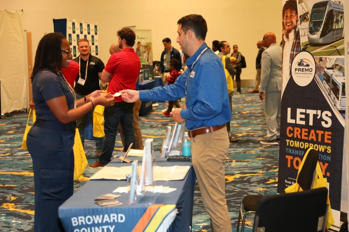 Photos from the 2026 Broward & Beyond Business Conference show attendees networking, visiting exhibitor booths, participating in panel discussions, and posing for group photos. Images include a BCT recruitment and outreach booth, conference speakers on stage, audience engagement, and business professionals connecting throughout the event. The conference took place in a large convention venue and focused on economic development, business growth, and community partnerships in Broward County.